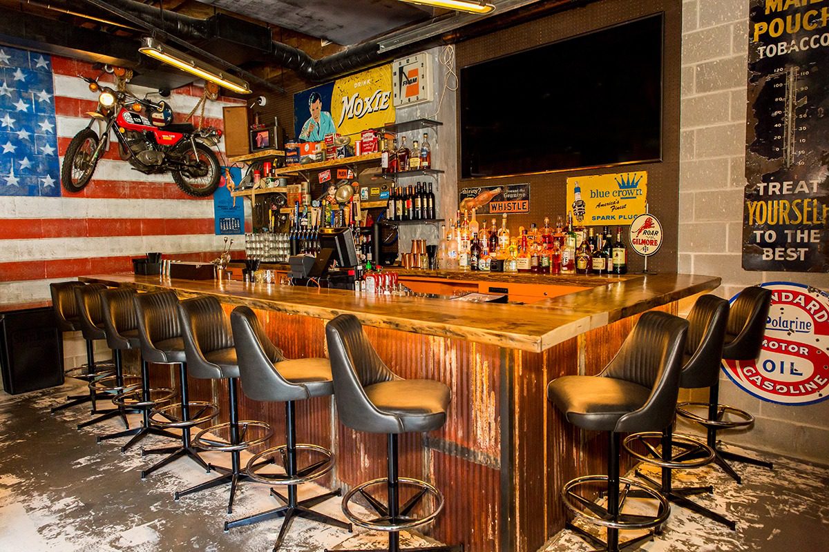 Cozy rustic bar with wooden counter and stools.