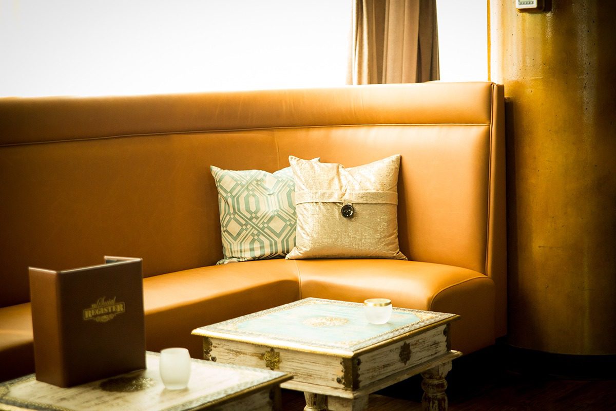 Cozy corner with a tan leather sofa and decorative pillows.