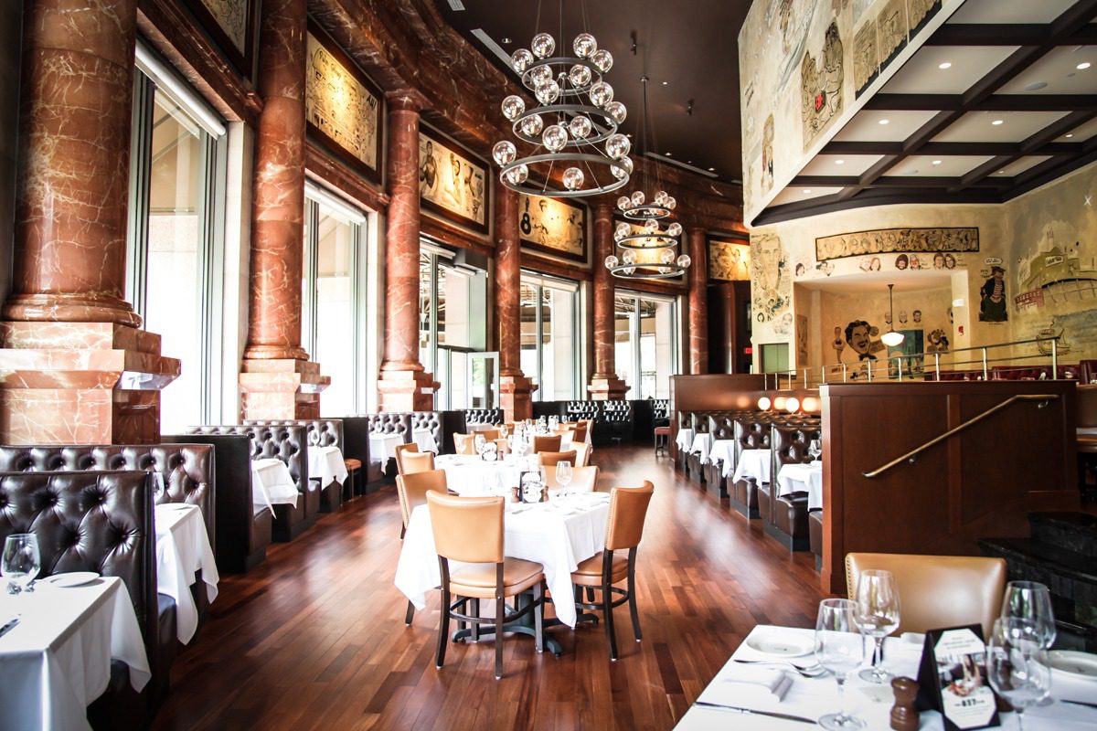Elegant restaurant interior with wooden floors and large windows.