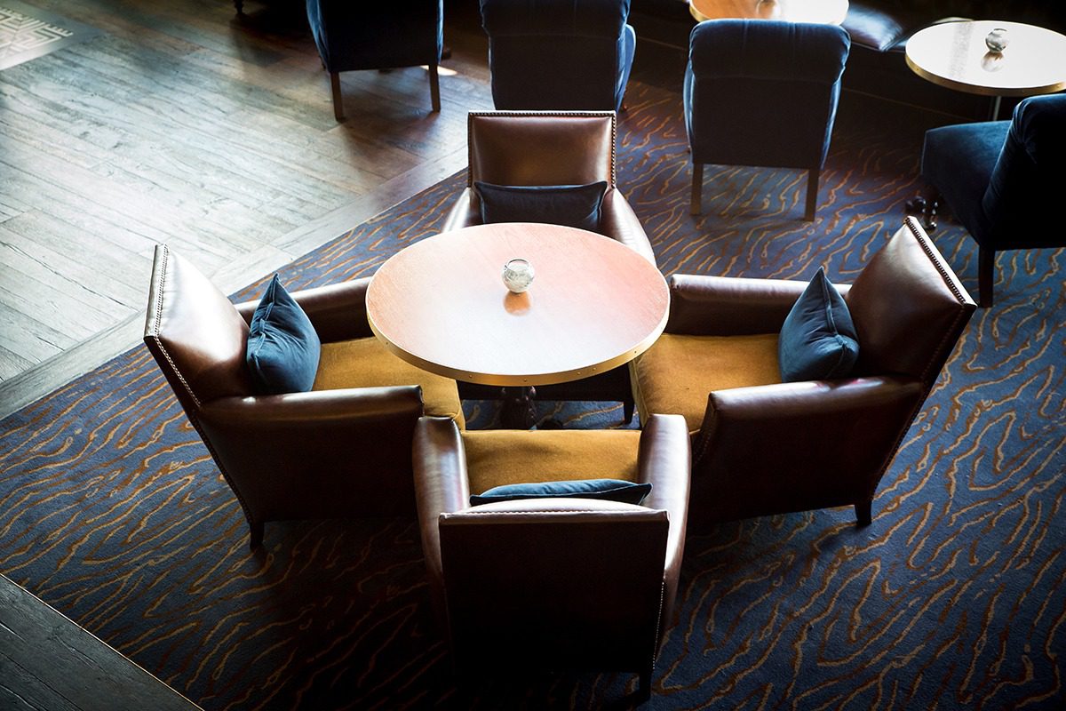 Cozy round table with four cushioned chairs in a warm, inviting room.