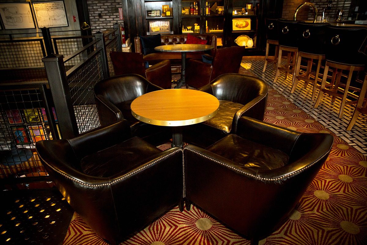 Cozy lounge seating with leather chairs around a wooden table.