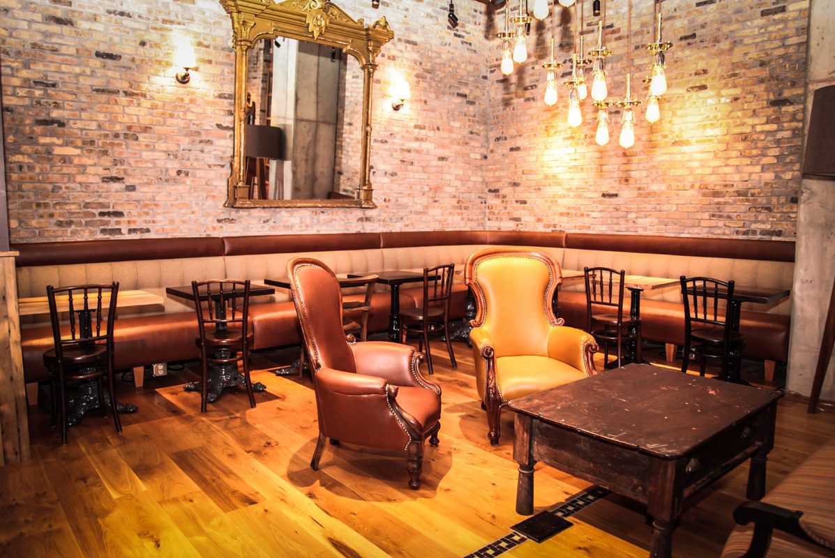 Cozy vintage-style seating area with exposed brick and warm lighting.