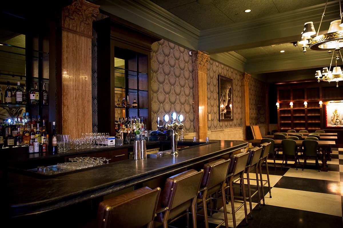 Elegant bar interior with wooden accents and dim lighting.