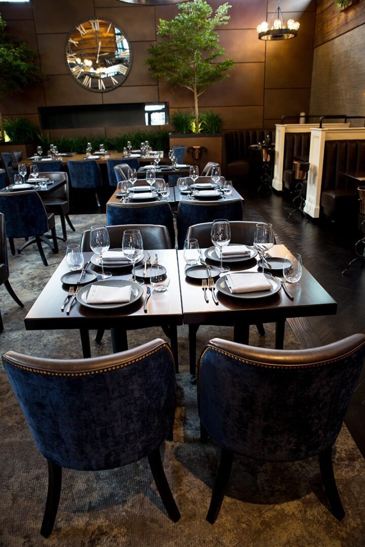 Elegant restaurant table setting with plush chairs and neatly arranged tableware.