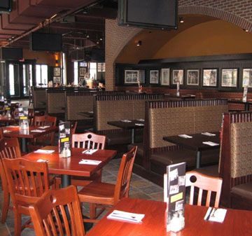 Cozy restaurant interior with wooden chairs and booths.