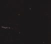Night sky with stars and a faint light trail.