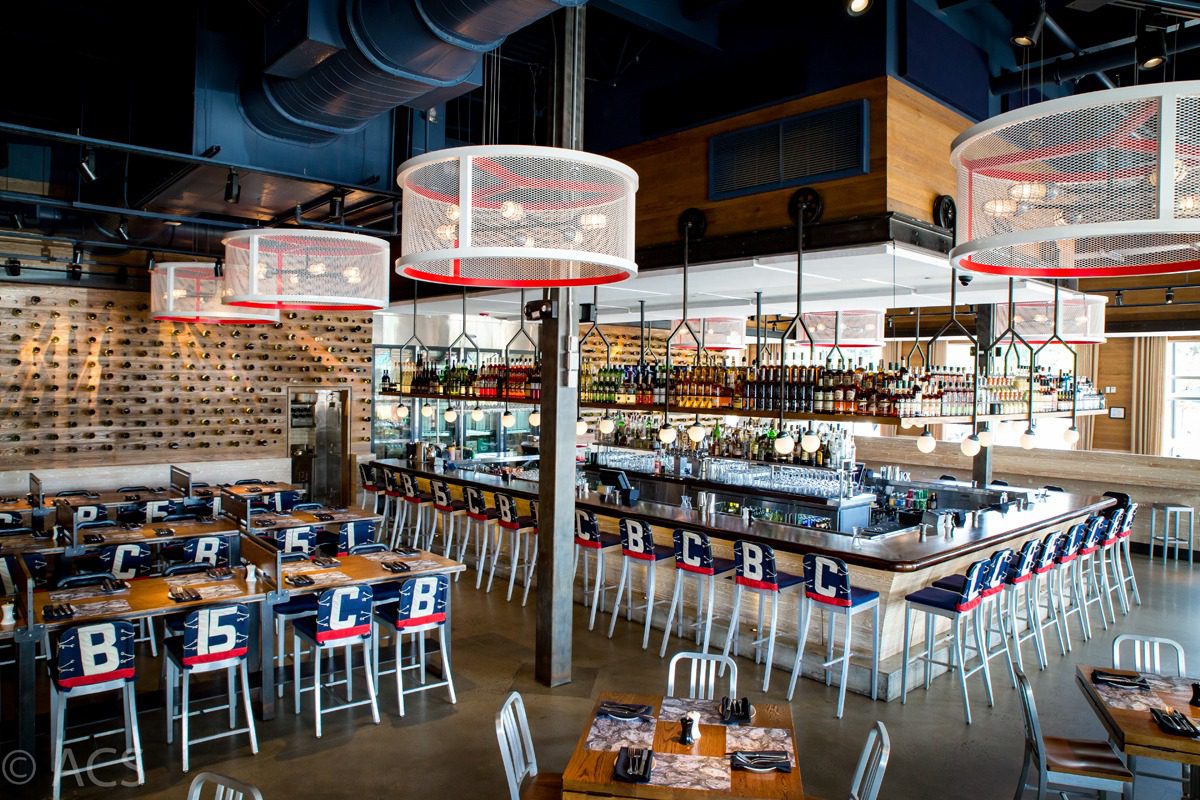 Modern restaurant interior with unique hanging storage and wooden chairs.