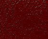 Close-up of a red surface with scattered white specks.