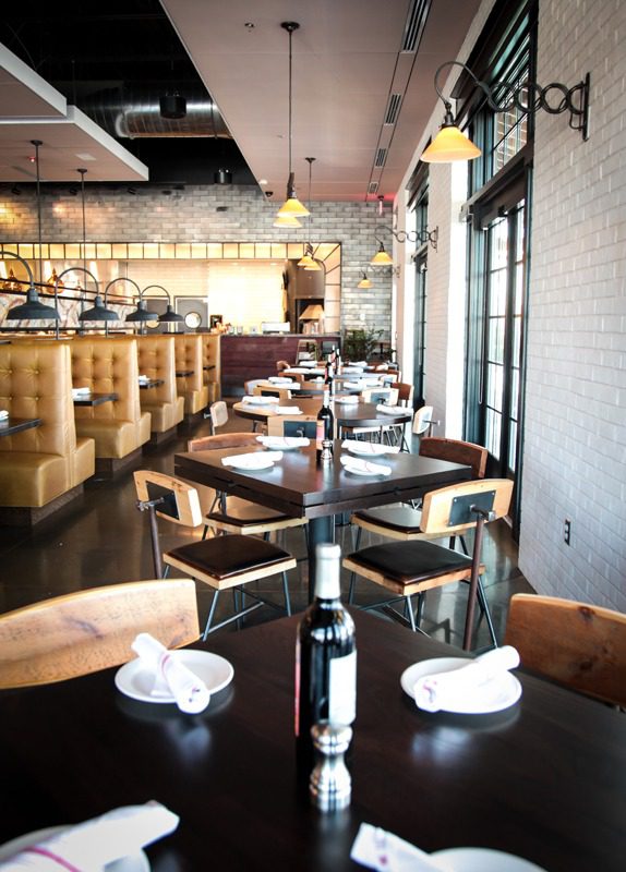 Cozy restaurant interior with wooden tables and modern lighting.