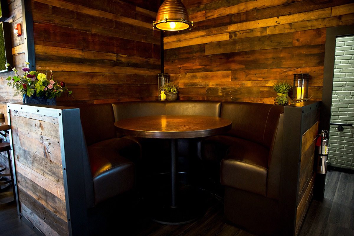 Cozy round booth seating with warm lighting and wooden walls.