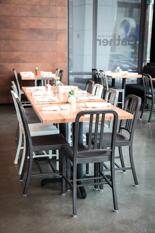 Empty wooden tables with metal chairs in a modern cafe.