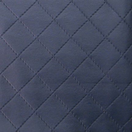 Close-up of navy blue quilted fabric with diamond pattern.