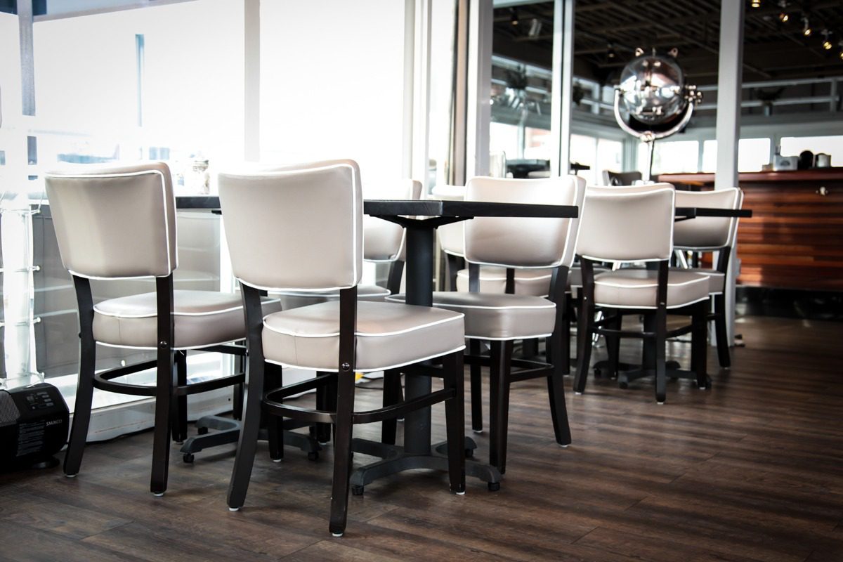 Modern dining chairs with white cushions in a stylish restaurant setting.
