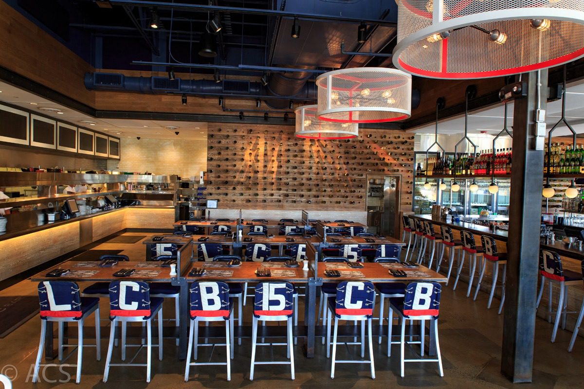 Bar seating with lettered cushions in a modern restaurant interior.