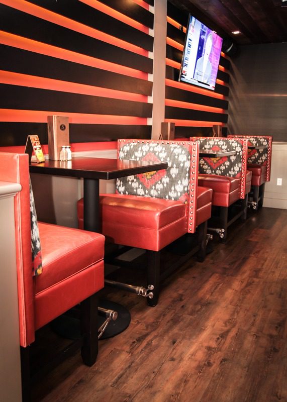 Red leather booths and chairs in a retro diner setting.