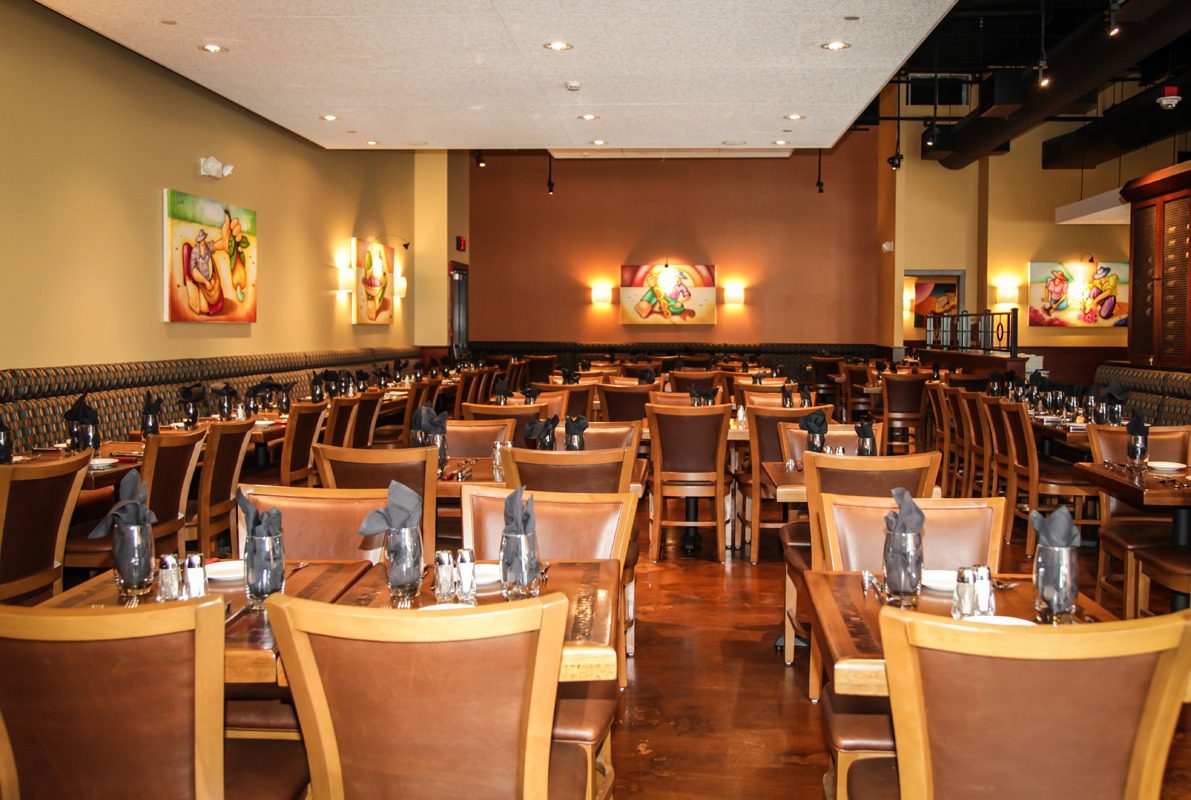 Cozy restaurant interior with wooden tables and chairs arranged neatly.