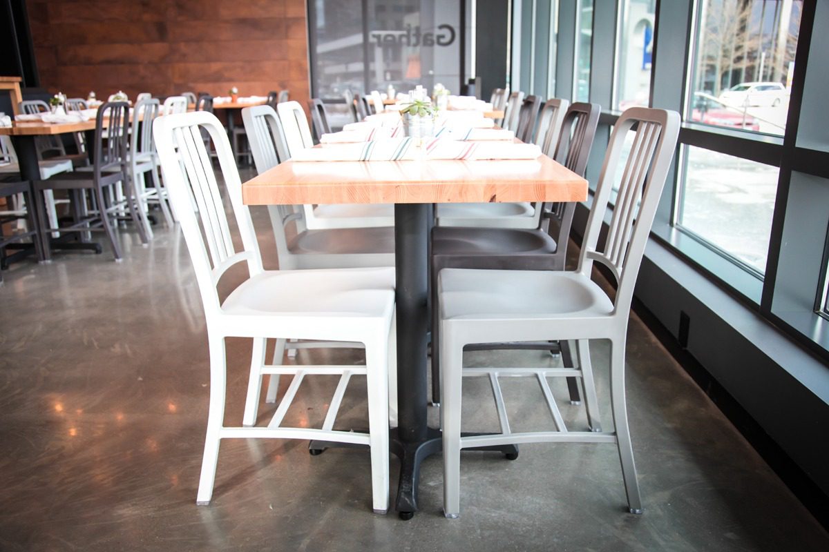 A modern dining table set with white chairs in a bright room.