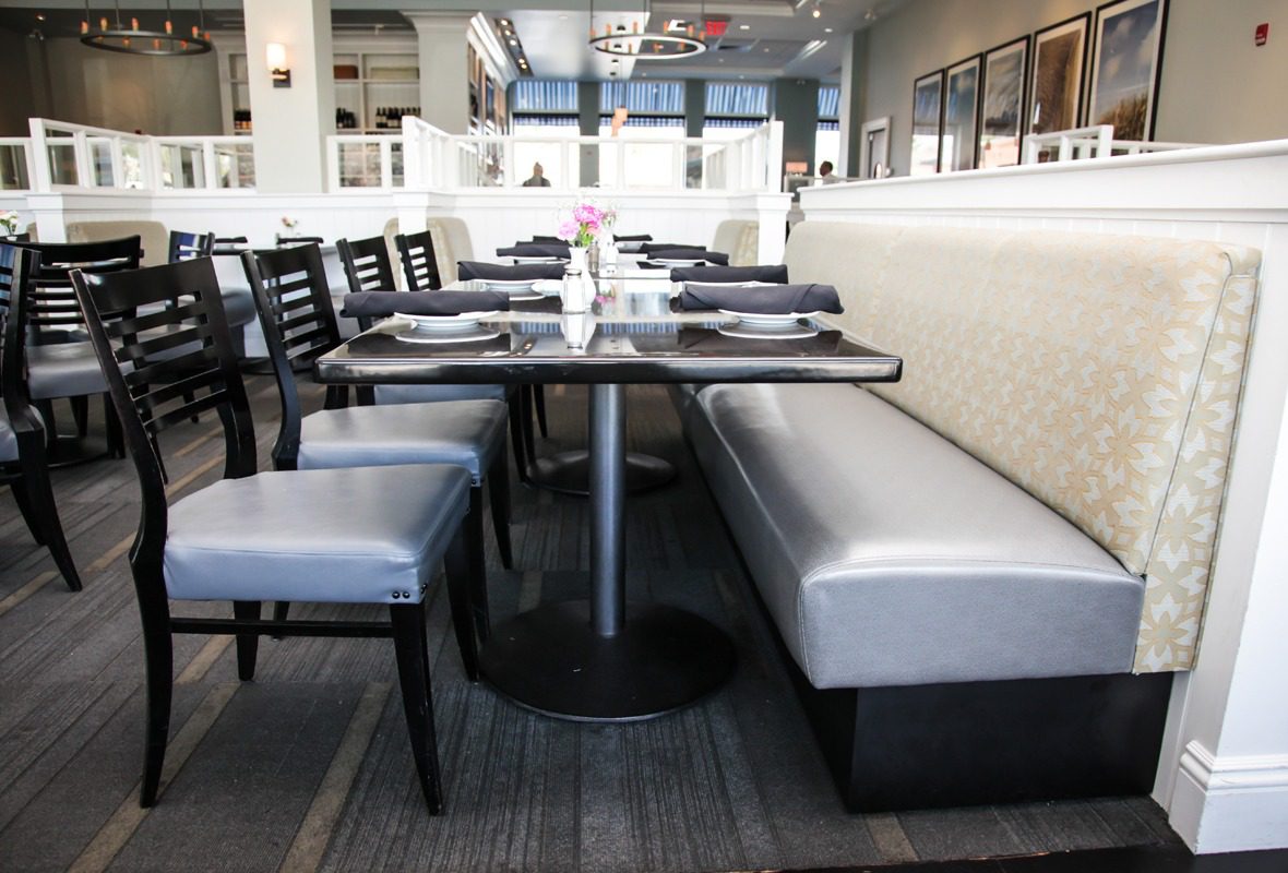 Modern dining area with booth and chairs.