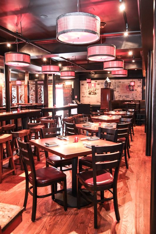 Cozy restaurant with wooden tables and red lighting.