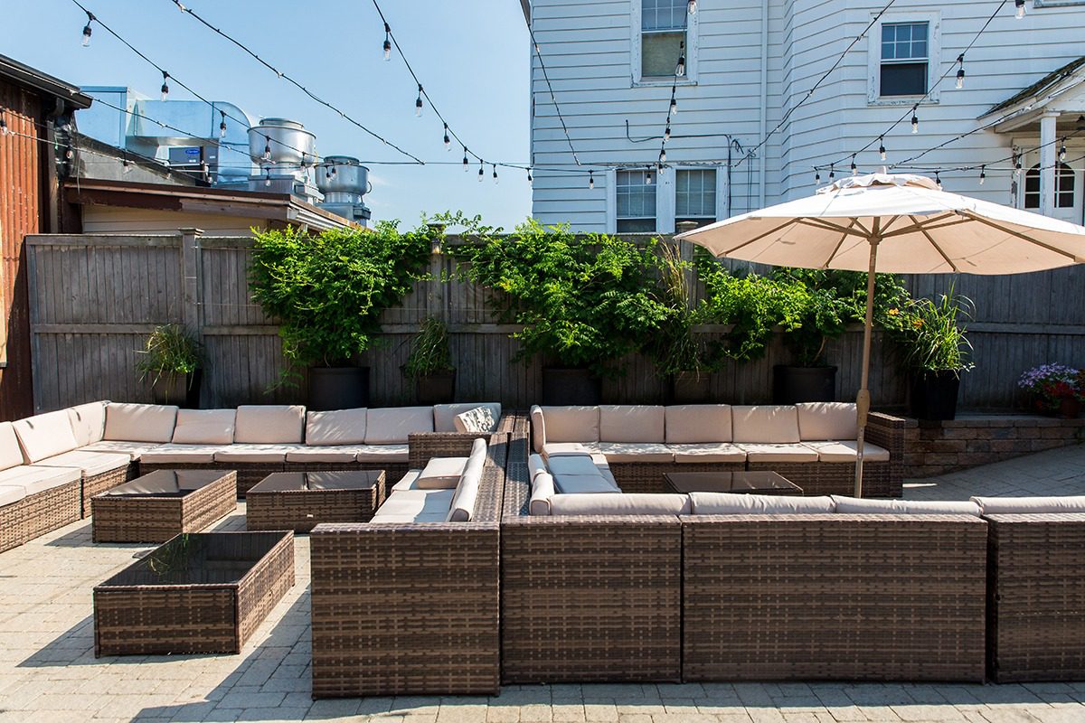 Outdoor patio with wicker furniture and string lights.