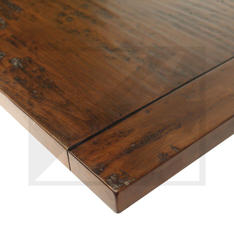 Close-up of a wooden table corner with visible grain and joinery.