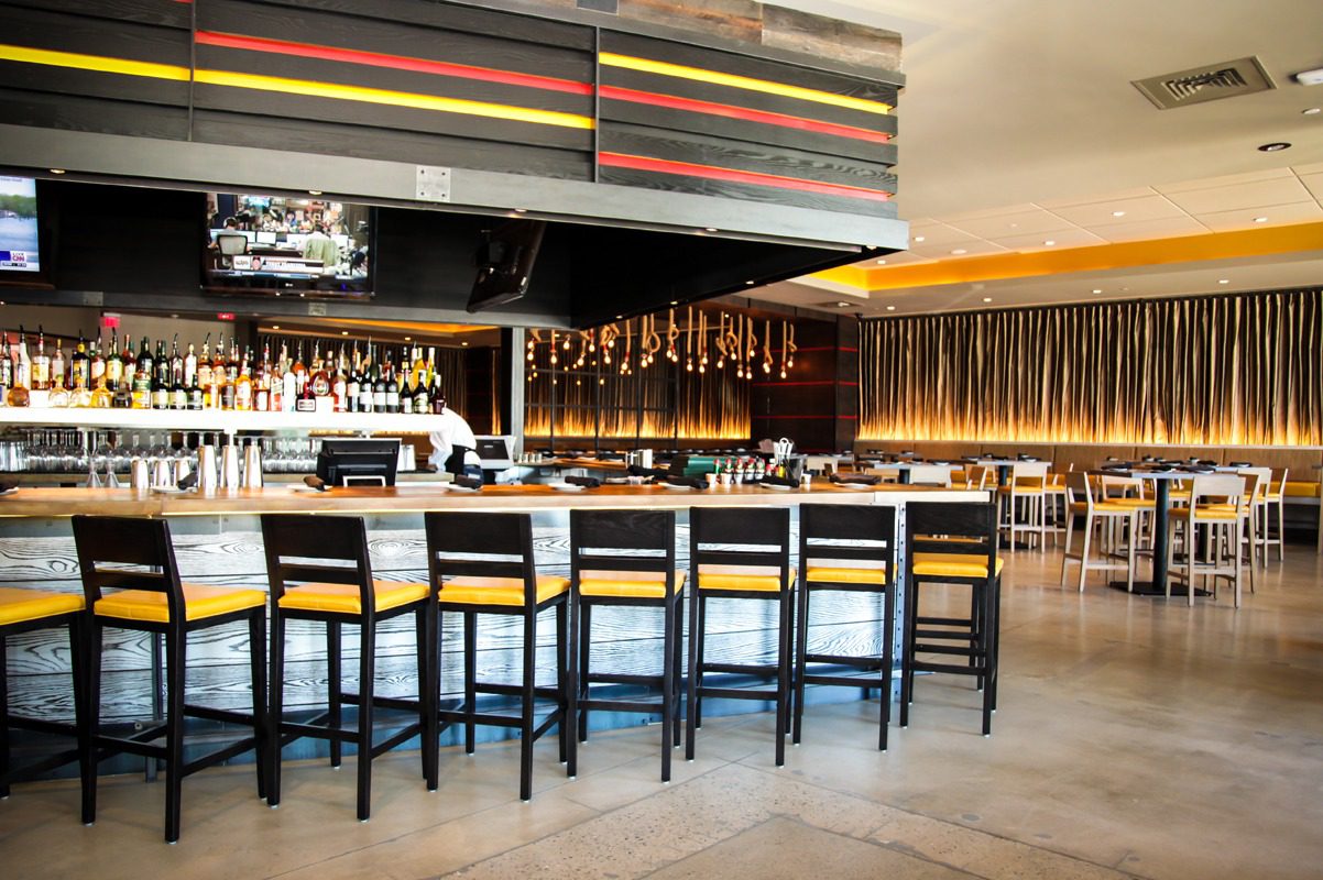 Modern bar with high chairs and warm lighting ambiance.
