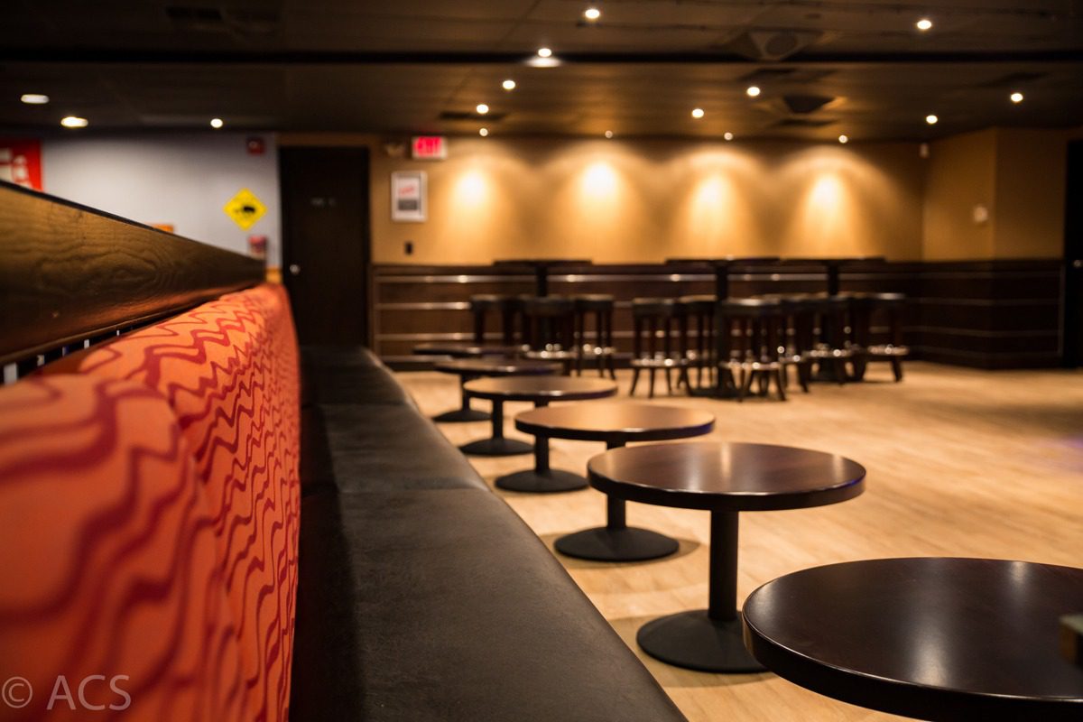 Empty modern lounge with round tables and warm lighting.