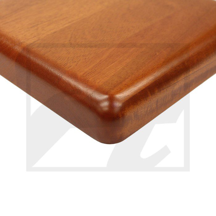 Close-up of a polished wooden table corner with rounded edges.