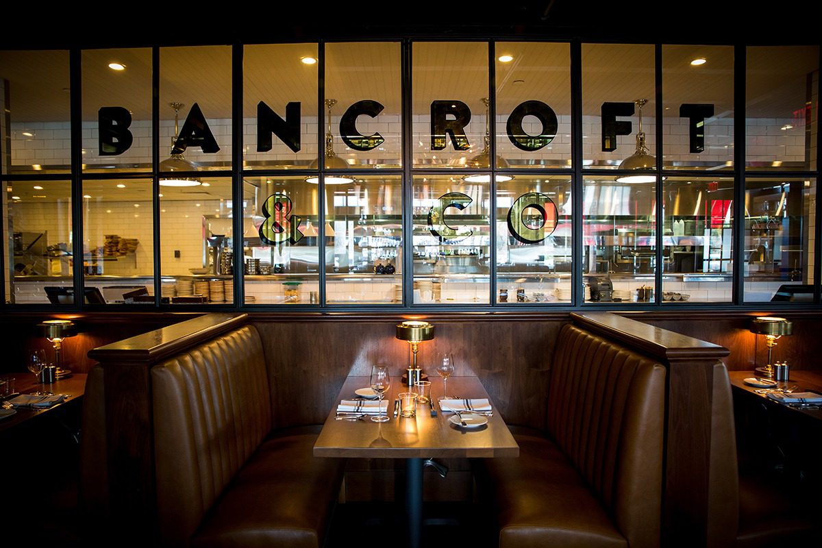 Cozy booth dining area with a view of a modern restaurant interior.
