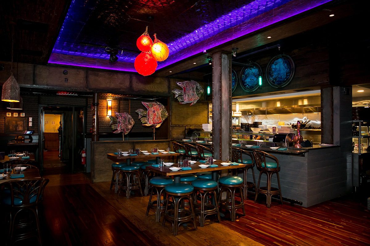 Cozy restaurant interior with vibrant lighting and bar seating.