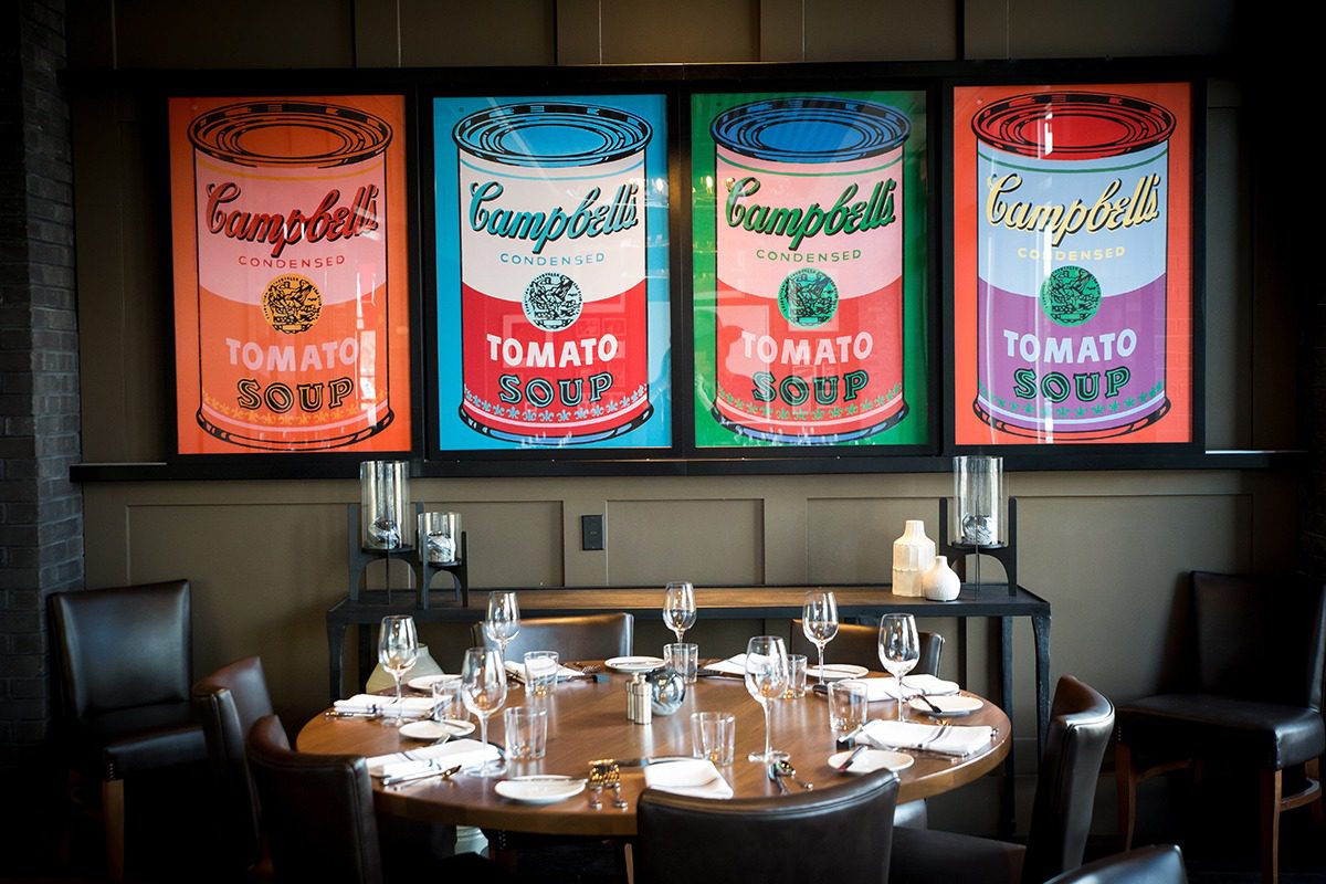 Dining area with pop art Campbell's soup cans artwork.