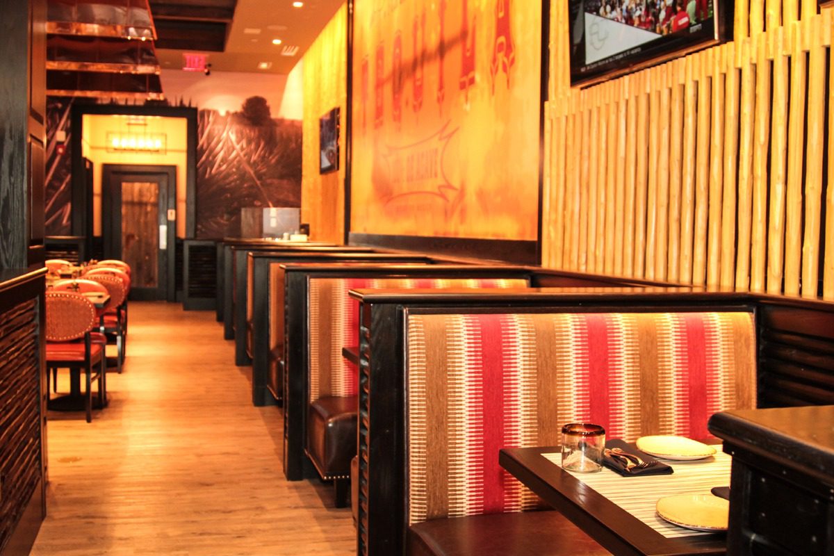 Cozy restaurant booths with warm lighting and rustic decor.