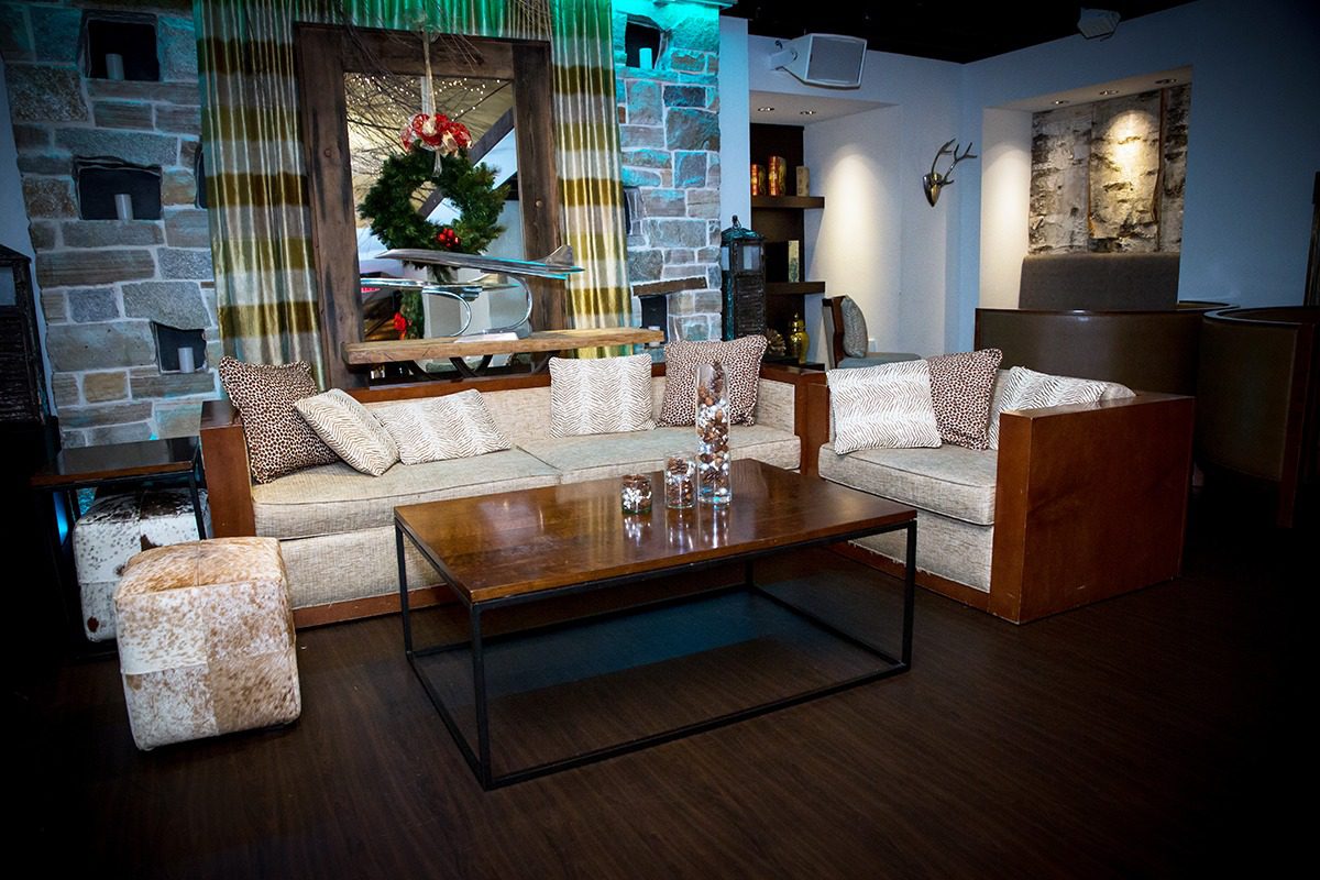 Cozy living room with modern furniture and festive wreath.