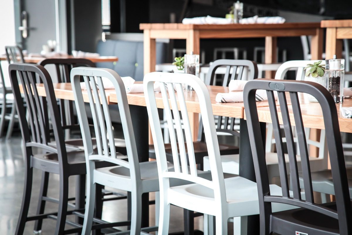 A row of white and gray chairs lined up in a cozy cafe setting.