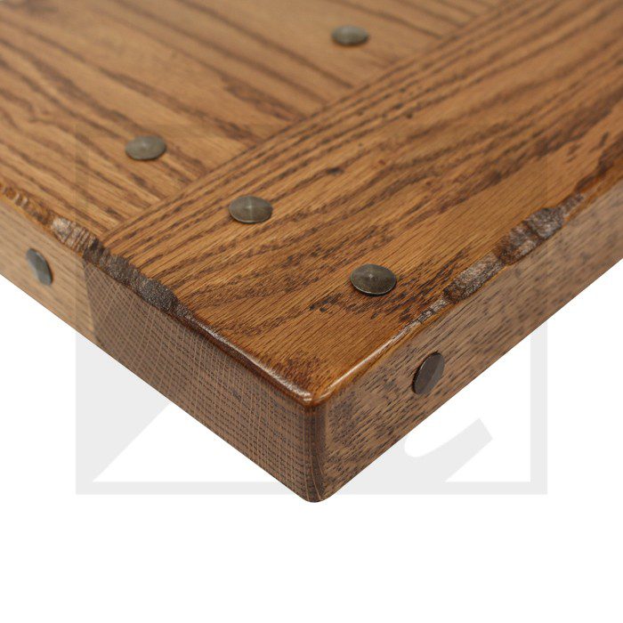 Close-up of a rustic wooden table corner with visible nails.