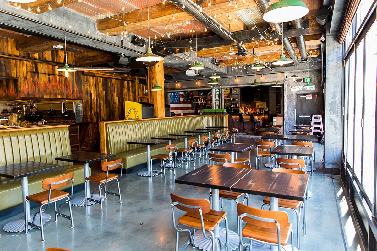 Empty rustic-style restaurant interior with wooden tables and chairs.