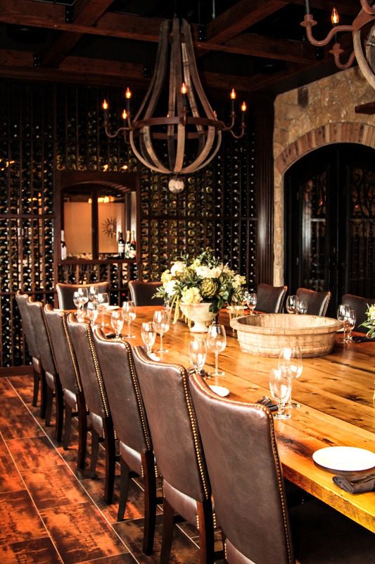 Elegant dining table set with floral centerpiece and warm lighting.