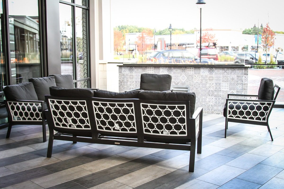 Modern black sofa with geometric patterned cushions in a bright living room.