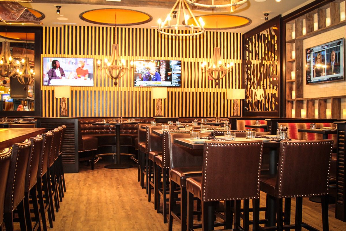 Elegant restaurant interior with wooden tables and warm lighting.