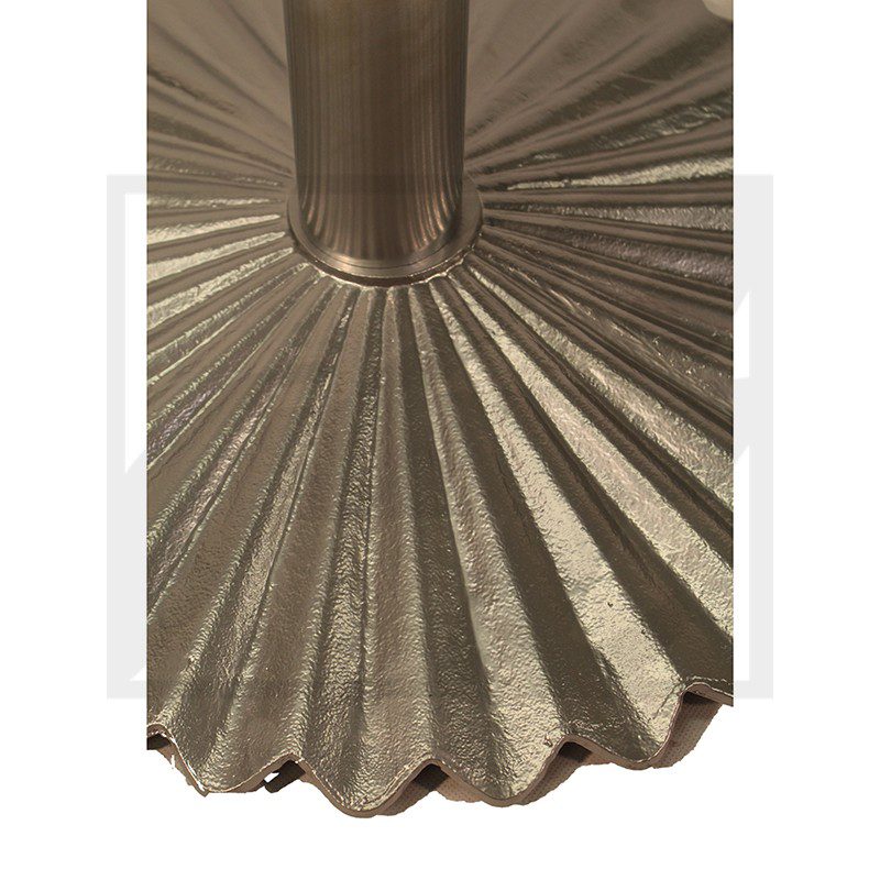 Metal object with radiating grooves around a central cylindrical part.