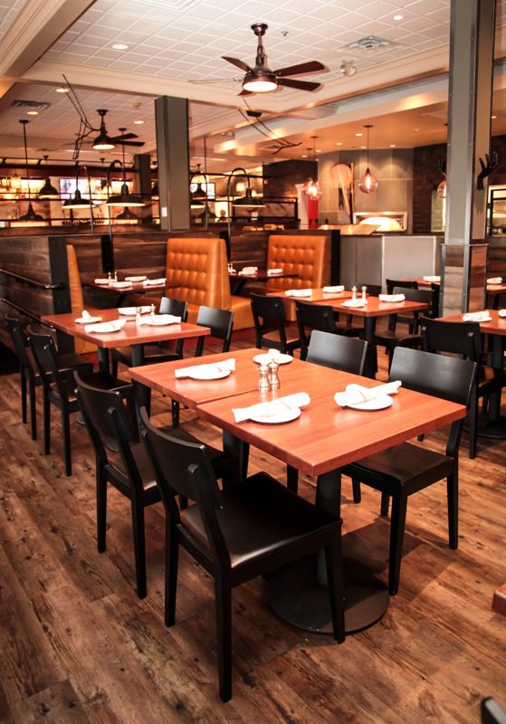 Cozy restaurant with wooden tables and black chairs.