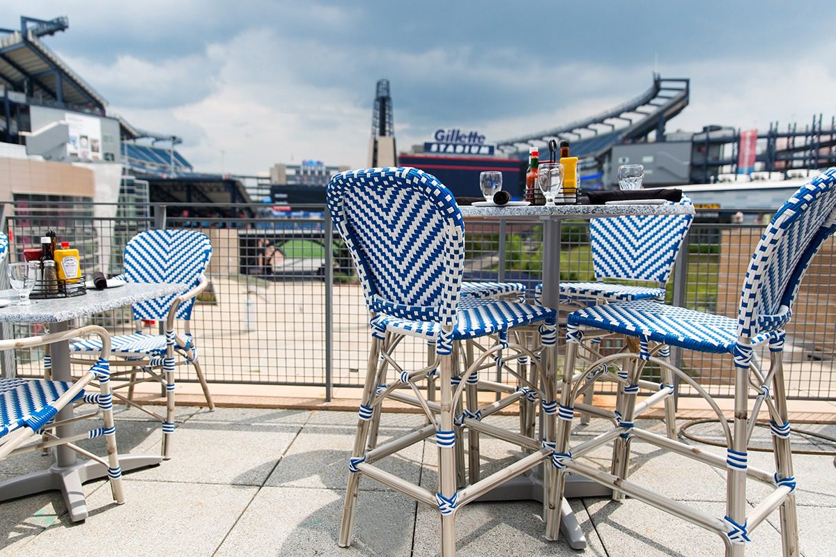 Outdoor seating with blue and white chairs on a rooftop patio.