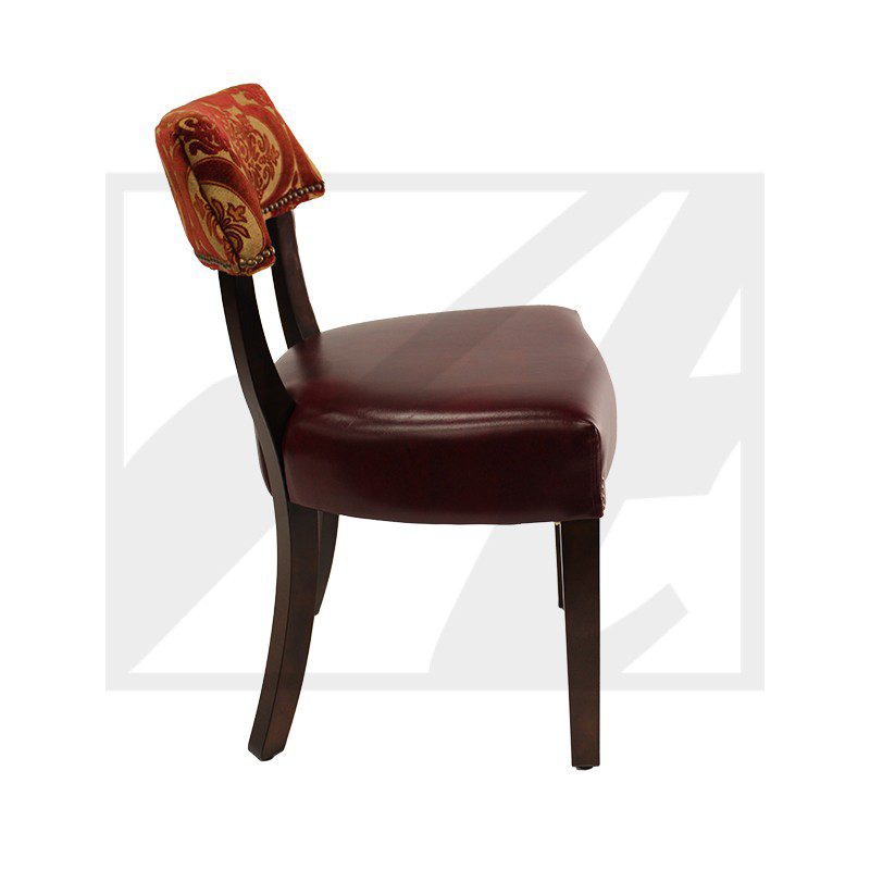Side view of a wooden chair with a cushioned seat and ornate backrest.
