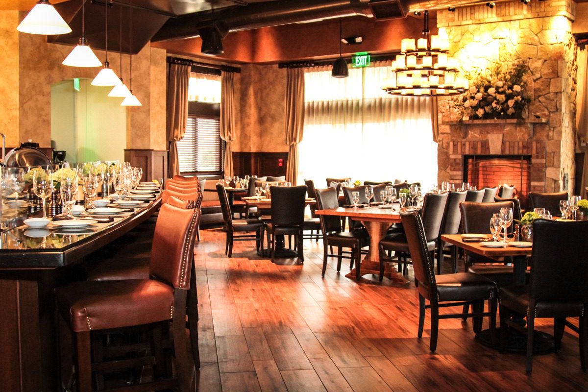 Cozy restaurant interior with warm lighting and wooden floors.