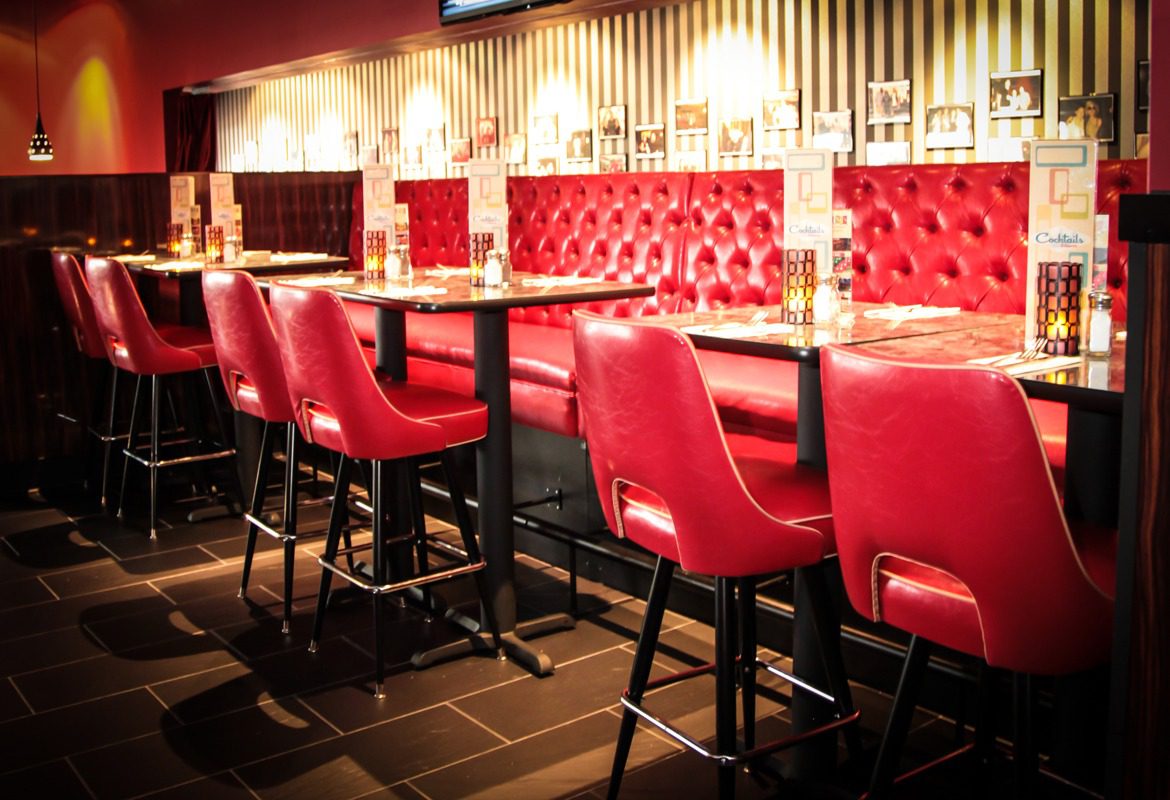 Stylish bar seating with red leather chairs and warm lighting.