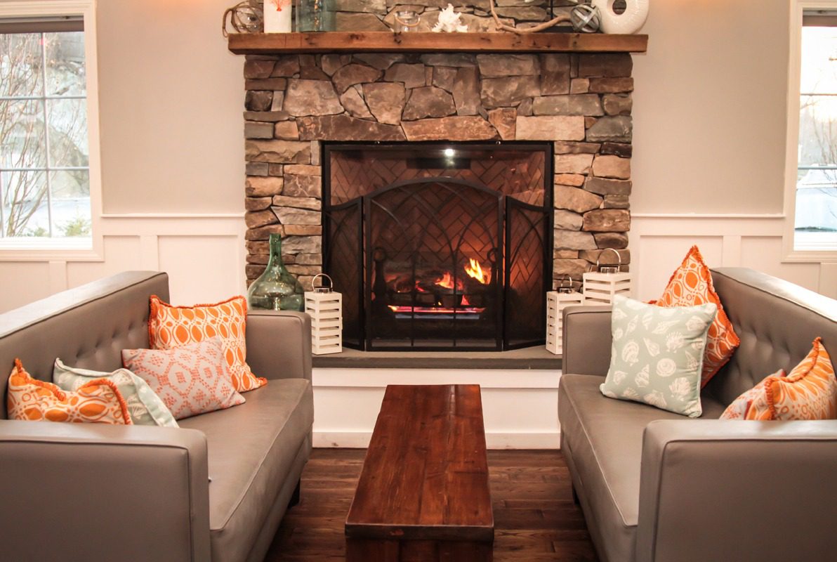 Cozy living room with a lit stone fireplace and comfortable sofas.
