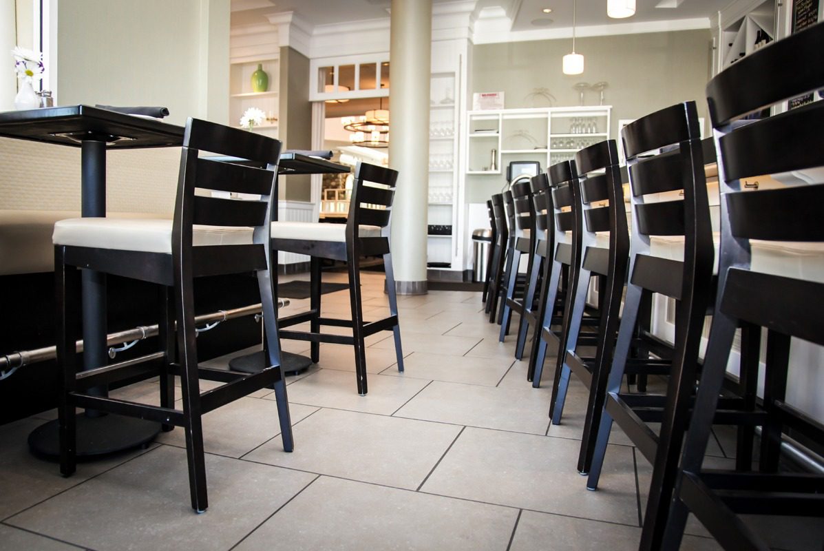 Empty black chairs neatly arranged in a modern restaurant.