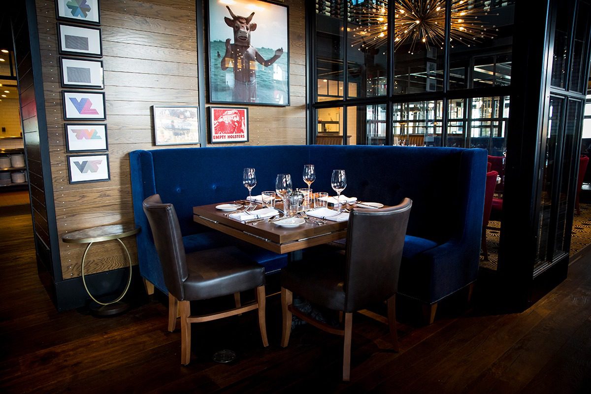Cozy restaurant corner with blue velvet seating and elegant table setting.