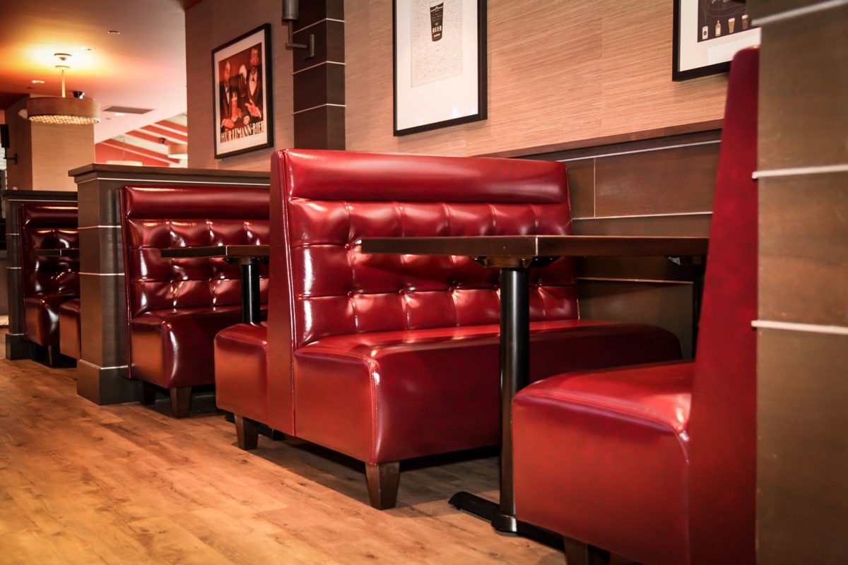 Cozy red leather booth seating in a warmly lit restaurant.