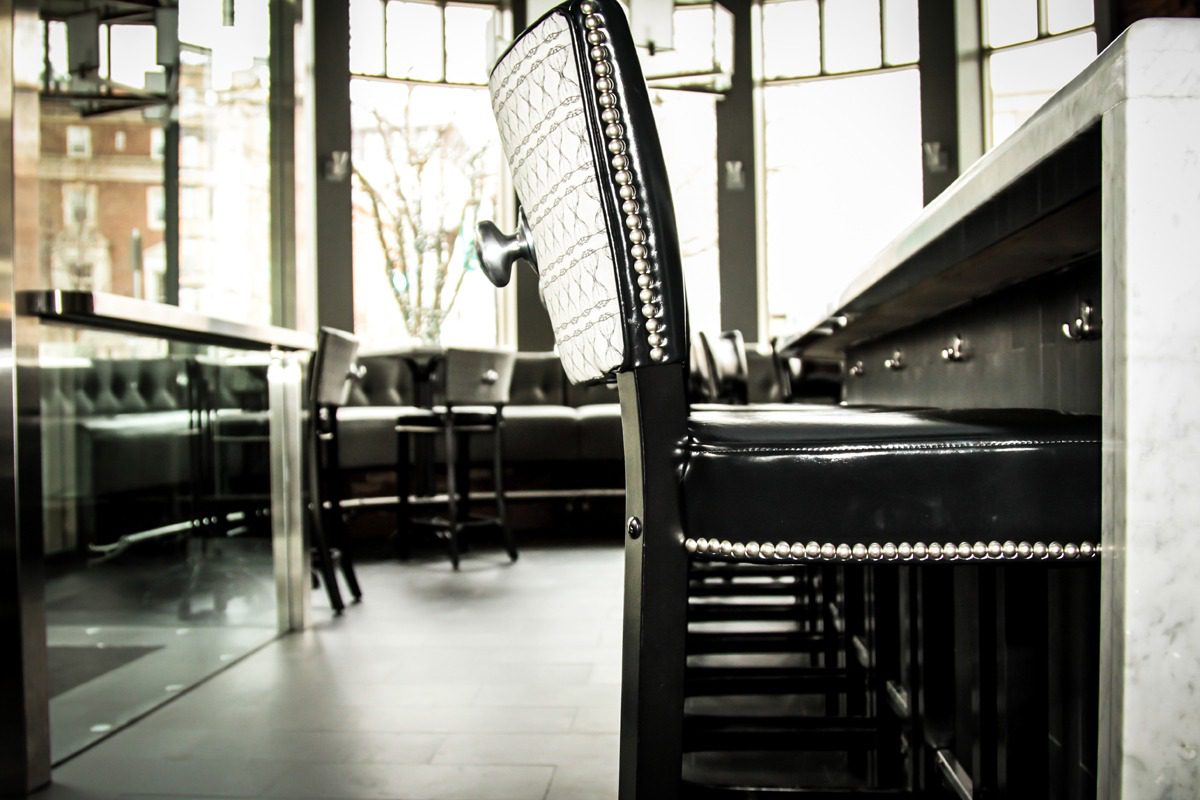 Close-up of a stylish black chair in a modern dining area.